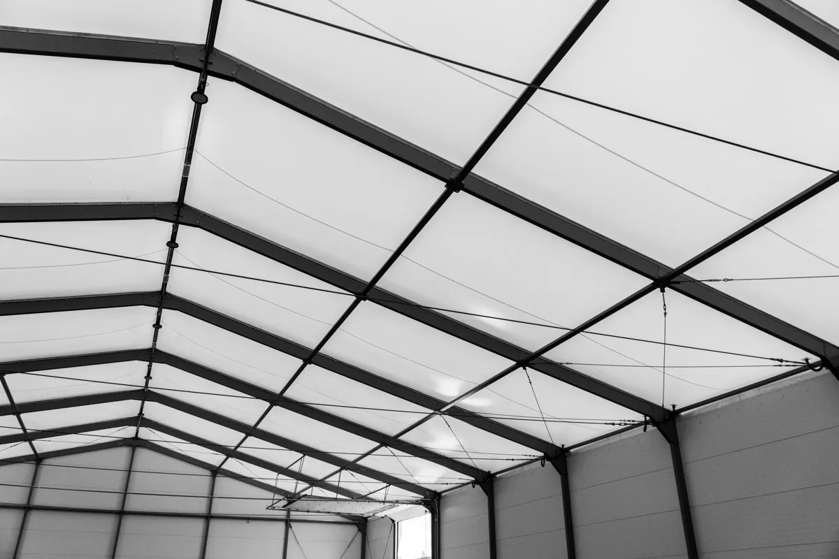 Innenansicht einer Lagerhalle mit lichtdurchlässiger Dachplane und Stahltragwerk